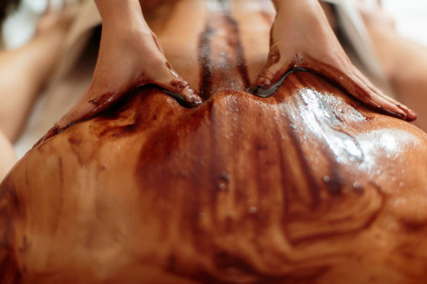Einreibung der Haut mit Schokolade für Massage